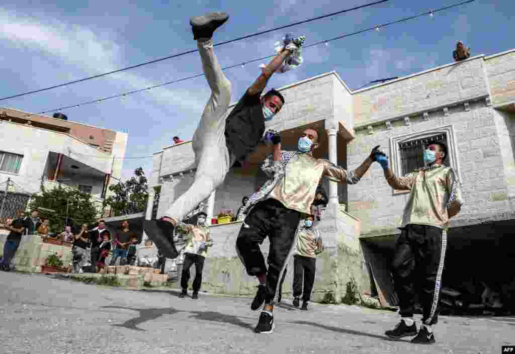 Dancers of the Palestinian Jafra Dabke Team perform a traditional dabke dance during a COVID-19 coronavirus pandemic lockdown in the village of Tarqumia northwest of Hebron in the occupied West Bank.