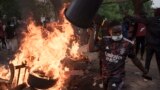 A demonstrator walks past a barricade set on fire during a protest in support of main opposition leader Ousmane Sonko in Dakar, Senegal, May 29, 2023. 