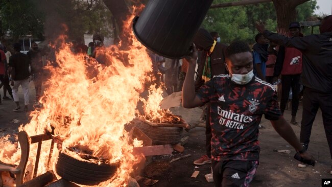 A demonstrator walks past a barricade set on fire during a protest in support of main opposition leader Ousmane Sonko in Dakar, Senegal, May 29, 2023.