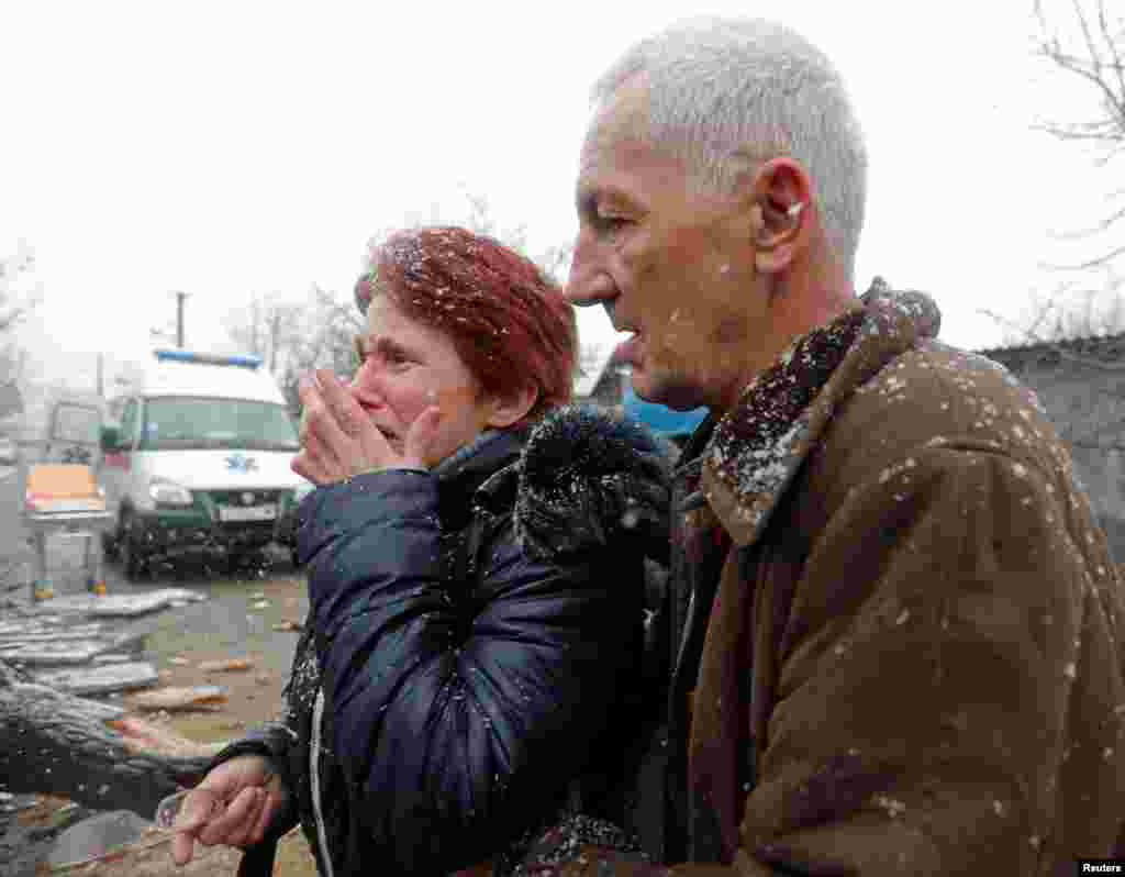 A woman reacts next to a damaged house following recent shelling in the separatist-controlled city of Donetsk, Ukraine, March 3, 2022.