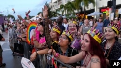 People watch as floats pass by during the Stonewall Pride Parade and Street Festival, June 17, 2023, in Wilton Manors, Fla.