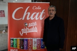 FILE - Fahed Arar, general manager of the Chat Cola Company poses next to an billboard with the company's brands that reads 'the Palestinian taste,' in the Palestinian company's bottling plant, in the West Bank city of Salfit, Feb. 13, 2025.