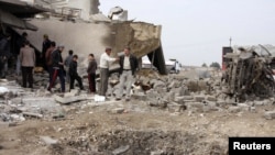 Warga berkumpul di tempat serangan bom di al-Mouafaqiyah, sebuah desa dekat Mosul, 390 kilometer utara Baghdad (17/12/2012). (Reuters/Khalid al-Mousuly)