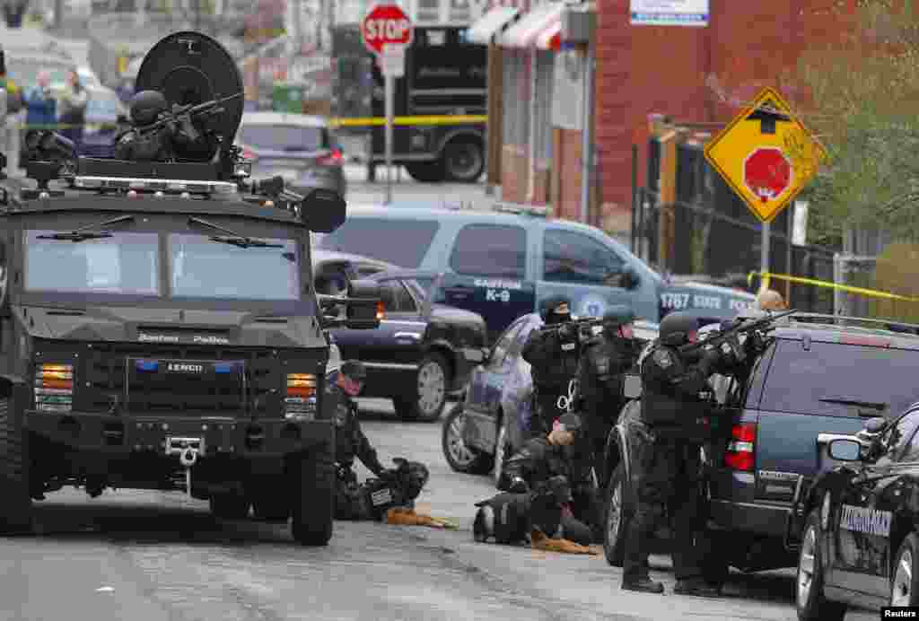 Police officers take position during a search for the Boston Marathon bombing suspects in Watertown, Massachusetts April 19, 2013. 