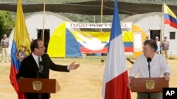 France's President Francois Hollande, left, speaks during a joint statement with Colombia's President Juan Manuel Santos, right, during a visit to a United Nations camp near an area where members of FARC, will turn over weapons to U.N. observers in La Venta, Colombia, Jan. 24, 2017. 