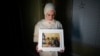FILE - Maryam Kamalmaz holds a photo of her father, Majd Kamalmaz, with some of his 14 grandchildren in Grand Prairie, Texas, Jan. 17, 2024. The Syrian-born American psychotherapist died while being held in Syria. His family has filed a lawsuit against the Syrian government.
