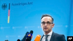 FILE - German Foreign Minister Heiko Maas briefs the media during a news conference on current developments in the worldwide spread of the coronavirus at the foreign ministry in Berlin, Germany, Tuesday, March 17, 2020.