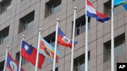 Sebuah tiang, ketiga dari kanan, tempat bendera nasional Nauru biasa berkibar, kosong di luar gedung Diplomatic Quarter di Taipei, Taiwan, Senin, 15 Januari 2024. (Foto: AP)