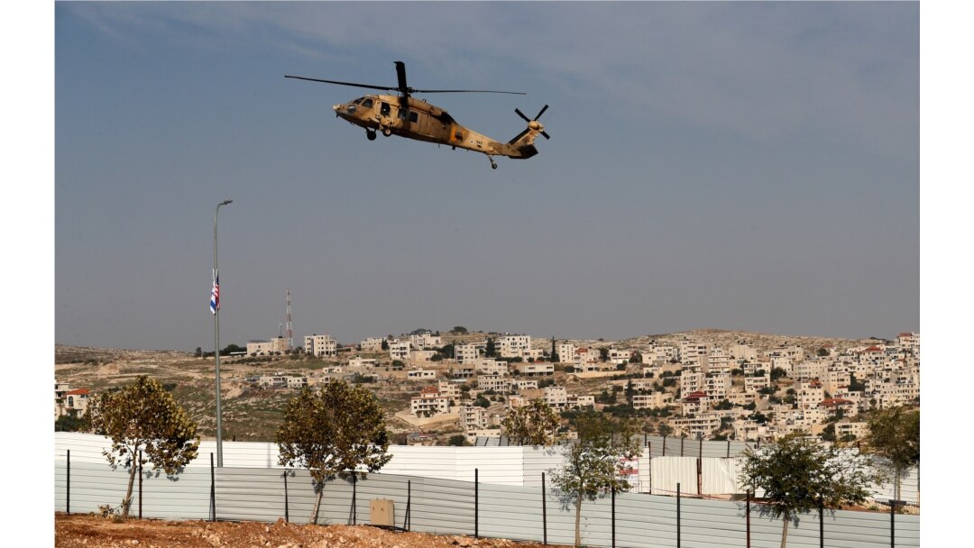 An Israeli Air Force Blackhawk helicopter carrying U.S. Secretary of State Mike Pompeo hovers over an industrial park near the Israeli Psagot settlement in the occupied West Bank, north of Jerusalem, Nov. 19, 2020.
