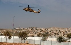 An Israeli Air Force Blackhawk helicopter carrying U.S. Secretary of State Mike Pompeo hovers over an industrial park near the Israeli Psagot settlement in the occupied West Bank, north of Jerusalem, Nov. 19, 2020.