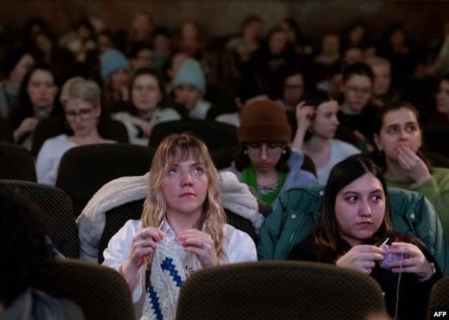 Women knit during the projection of the movie 'The Devil Wears Prada' at the Votive Cinema in Vienna, Austria, on February 16, 2025. (Photo by JOE KLAMAR / AFP)