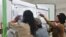 Para petugas melakukan Rekapitulasi Suara di Balai Desa Maliwuko, Kecamatan Lage Kabupaten Poso, Sulawesi Tengah (VOA/Yoanes).