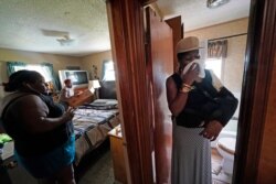 Rakisha Murray, right, reacts as she sees the damaged home of her sister, Patricia Mingo Lavergne, background, in Lake Charles, La., after they returned from evacuation in the aftermath of Hurricane Laura, Aug. 30, 2020.
