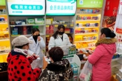 Staff members sell masks at a Yifeng Pharmacy in Wuhan, China, Jan. 22, 2020.