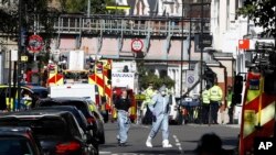 Agentes de policía caminan dentro del área acordonada donde un ataque con explosivo casero ocurrió en una estación subterránea del metro de Londres. Septiembre 15, 2017.