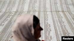 Žena stoji ispred Memorijalnog centra tokom ceremonije pokopa 136 novoidentifikovanih žrtava u Potočarima, kod Srebrenice, Bosna i Hercegovina, 11. jula 2015.