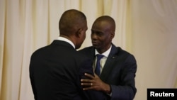 Premye minis ayisyen an Jean Henry Ceant (agoch) kap bay akolad ak prezidan aysiyen an Jovenel Moise pandan seremoni inogirasyon Mèt Céant kòm nouvo chèf gouvènman peyi a. Palè Nasyonal 17 septsnm 2018. Foto: REUTERS/Andres Martinez Casares - RC1493789FD0