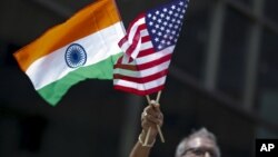 FILE - A man holds the flags of India and the U.S. at an India Day Parade in New York City, Aug. 16, 2015.