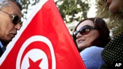 Femme tunisienne tenant un drapeau avec son doigt taché d'encre après le vote dans un bureau de vote à Tunis 23 Octobre , 2011