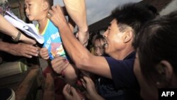 Chinese families evacuate their homes in the outskirts of Shanghai on August 7, 2012, ahead of Typhoon Haikui.