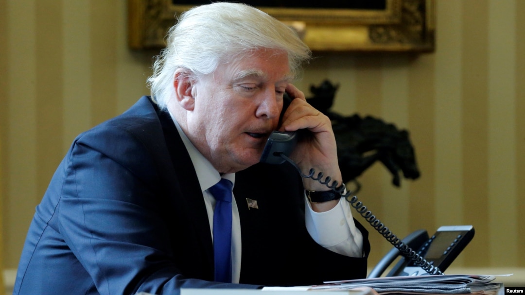 FILE - President Donald Trump conducts a phone call in the Oval Office at the White House in Washington, Jan. 28, 2017.