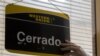 Un oficinista de Western Union coloca el cartel de cerrado en su último día de trabajo en La Habana, Cuba, el lunes 23 de noviembre de 2020.