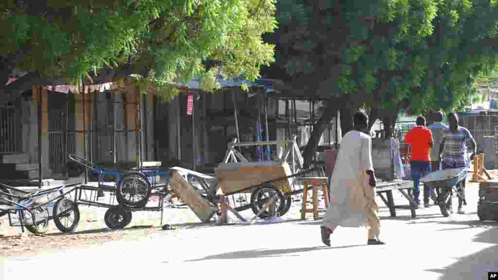 Mutane sun tsere suna tsallake shingaye, kuma sun rufe shagunansu biyo bayan harin kunar bakin waken na, Maiduguri, Najeriya, Talata, Nuwamba 25, 2014.