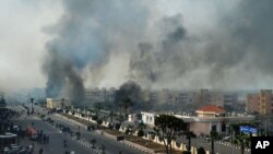 Asap hitam membumbung memenuhi angkasa Port Said saat warga Mesir bentrok dengan polisi, 27 Januari lalu (Foto: dok). Ratusan pemrotes memenuhi jalanan kota Mesir Senin malam (28/1) dan tidak memperdulikan pemberlakuan jam malam dan keadaan darurat di tiga kota,Port Said, Ismailiya dan Kota Suez. 