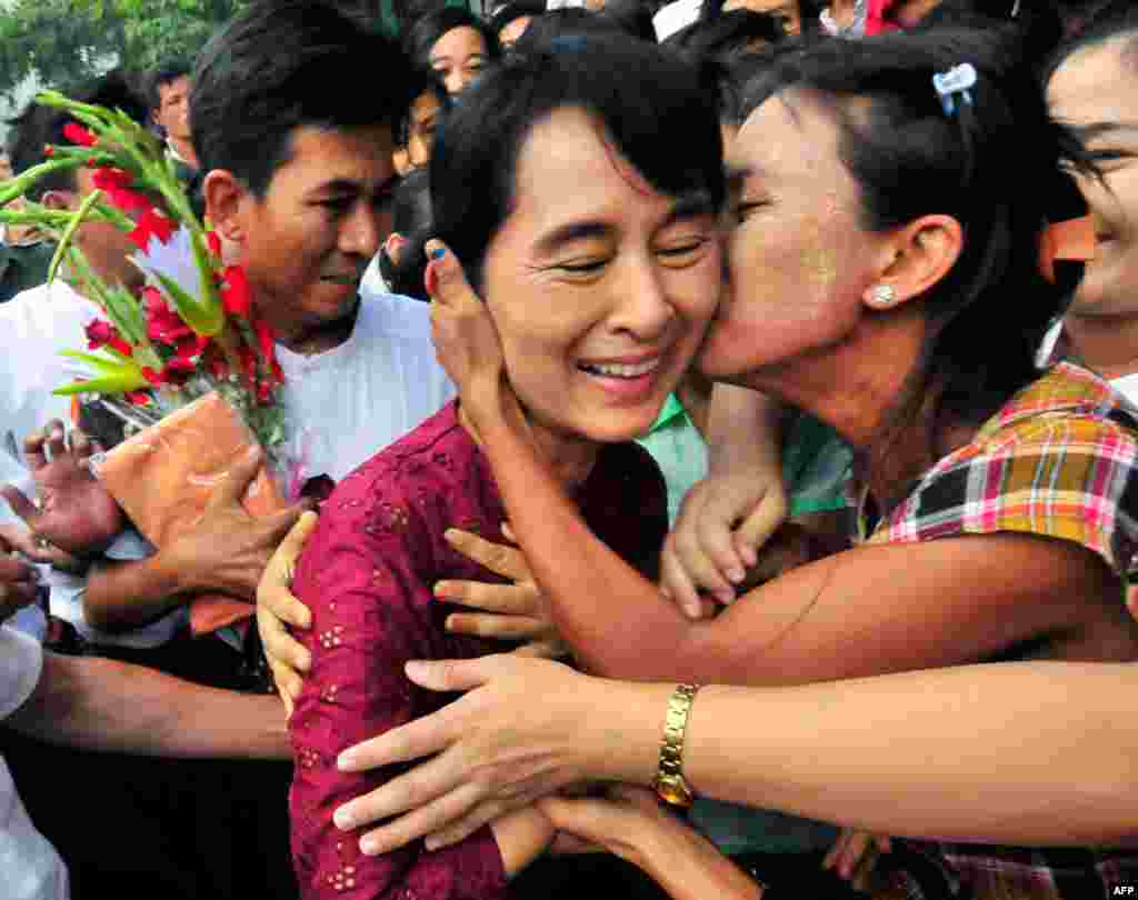 7 tháng 7: Lãnh tụ đối lập Aung San Suu Kyi được người dân Miến Điện hoan nghênh khi bà đến thăm chợ Nyaung Oo. Bà đến đó cùng với con trai Kim Aris và thành viên trong đảng của bà. (AP Photo/Khin Maung Win)