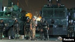 Riot policemen stand guard outside the French embassy in Sanaa, Yemen, September 19, 2012.