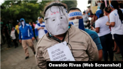 បាតុករ​ម្នាក់​ដែល​ពាក់​ស្រោម​មុខ​លោក​ប្រធានាធិបតី​នីការ៉ាហ្គា Daniel Ortega ចូលរួម​នៅ​ក្នុង​ការ​ដើរ​ក្បួន​មួយ​ដើម្បី​គាំទ្រ​ដល់​ព្រះវិហារ​កាតូលិក នៅ​ក្នុង​ក្រុង León ប្រទេស​នីការ៉ាហ្គា កាលពី​ថ្ងៃទី២៨ ខែកក្កដា ឆ្នាំ២០១៨។
