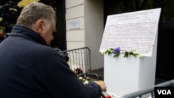 A man stands before the memorial for the victims of the Bataclan attack, Nov. 11, 2017, in Paris. 