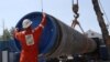 FILE - A worker puts a cap to a pipe at the construction site of the Nord Stream 2 gas pipeline, near the town of Kingisepp, Leningrad region, Russia, June 5, 2019. 