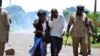 Supporters of former Foreign Affairs minister flee tear gas on March 11, 2013 during a demonstration in Blantyre. 