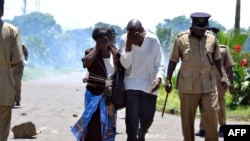 Supporters of former Foreign Affairs minister flee tear gas on March 11, 2013 during a demonstration in Blantyre. 