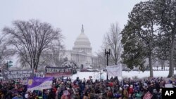 Activistas antiaborto marchan durante la Marcha anual por la Vida frente a la Corte Suprema el viernes 19 de enero de 2024, en Washington, con el Capitolio al fondo.