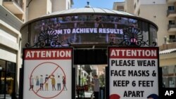 Signs with social distancing guidelines and face mask requirements are posted at an outdoor mall amid the COVID-19 pandemic in Los Angeles,June 11, 2021. 