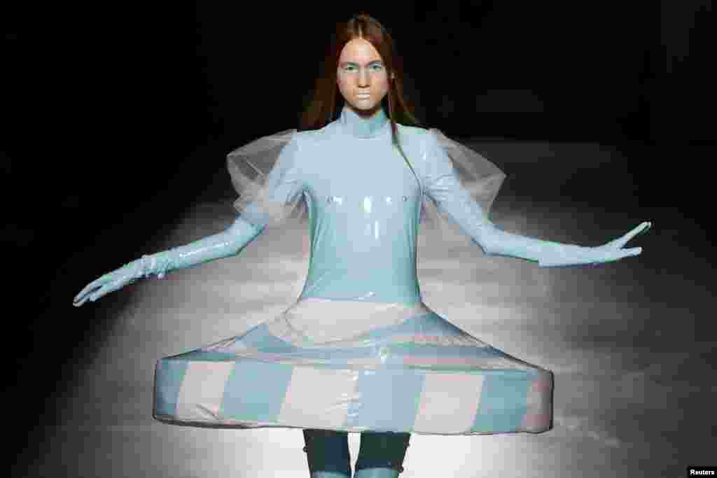 A model presents a creation by graduates of the Open Fashion Studio clothing design school during Ukrainian Fashion Week in Kyiv, Ukraine, Sept. 3, 2020.