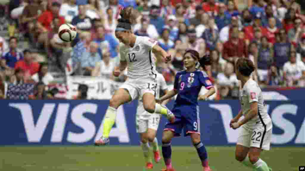 Pemain tim AS Lauren Holiday (12) menanduk bola di atas pemain Jepang Nahomi Kawasumi (9) pertandingan final Piala Dunia Putri di Vancouver, Kanada (5/7). (AP/Elaine Thompson)