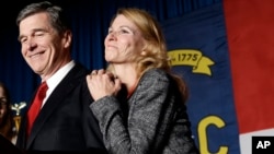 FILE - North Carolina Democratic candidate for governor Roy Cooper and his wife, Kristin, greet supporters during an election night rally in Raleigh, N.C., Nov. 9, 2016. 