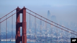 The San Francisco skyline is obscured by smoke from wildfires, as the Golden Gate Bridge rises in the foreground, Aug. 19, 2020, in this view from the Marin Headlands near Sausalito, Calif.
