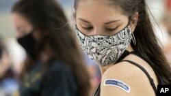 FILE - In this Thursday, April 8, 2021, file photo, Kent State University student Regan Raeth, of Hudson, Ohio, looks at her vaccination bandage as she waits for 15 minutes after her shot in Kent, Ohio. On Wednesday, May 12, 2021, Gov. Mike DeWine announc