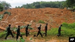 FILE - Sri Lankan army soldiers carry out a search operation in Elangapitiya village in Aranayaka, about 70 kilometers (45 miles) north of Colombo, Sri Lanka, May 19, 2016. Heavy rains pounded the central Sri Lankan region where at least three villages were swallowed by mountains of mud.