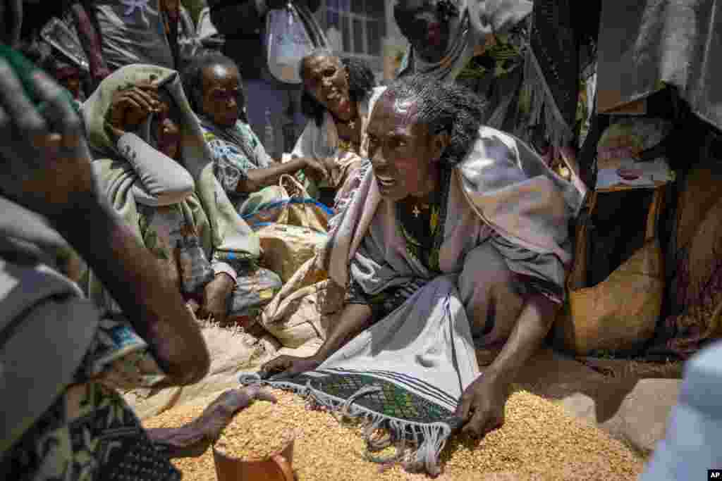 An Ethiopian woman argues with others over the allocation of yellow split peas distributed by the Relief Society of Tigray in the town of Agula, in the Tigray region of northern Ethiopia, May 8, 2021.