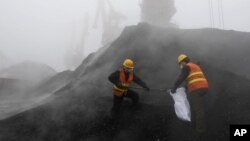 FILE - Employees from the local Entry-Exit Inspection and Quarantine Bureau collect samples of coal at a port in Rizhao, Shandong province.