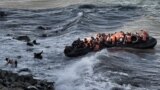 Refugees and migrants try to reach the shore on the Greek island of Lesbos, despite a rough sea, after crossing the Aegean Sea from Turkey, Oct. 30, 2015..
