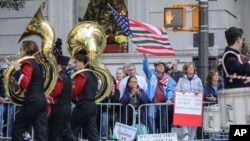 Viewers at the Columbus Day Parade wave a U.S. flag with Italian national colors and signs of expression, Oct. 14, 2019, in New York. 
