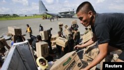 Philippine Army personnel unload relief goods to be transported to regions affected by Typhoon Bopha, from the Marine Corps KC-130J Hercules aircraft inside the International Airport in Davao, Mindanao December 15, 2012. United States Marines together wit