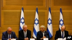 FILE - Avigdor Lieberman, from left, Benny Gantz, Yair Lapid and Israel's new prime minister Naftali Bennett hold a first cabinet meeting in Jerusalem. 
