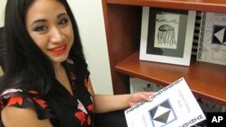 Britt'Nee Brower shows an Inupiat coloring book she published and she talks about the new Inupiat Eskimo language option now available for Facebook bookmarks, action buttons. Alaskans made the option a reality through the social media giant's community translation tool, Anchorage, Alaska, Aug. 23, 2018.